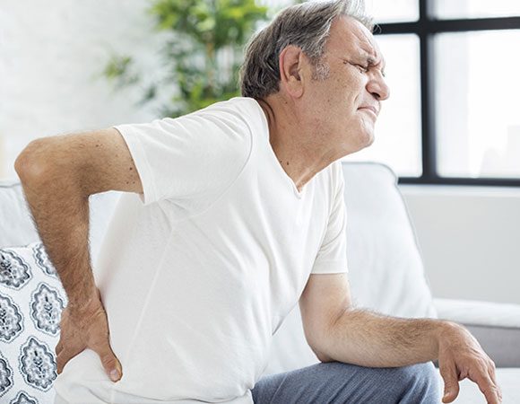 Senior patient holding back in pain