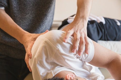 Physical therapist massaging patient's shoulder
