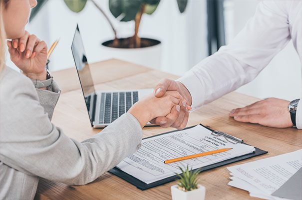 Patient shaking hands with doctor over desk
