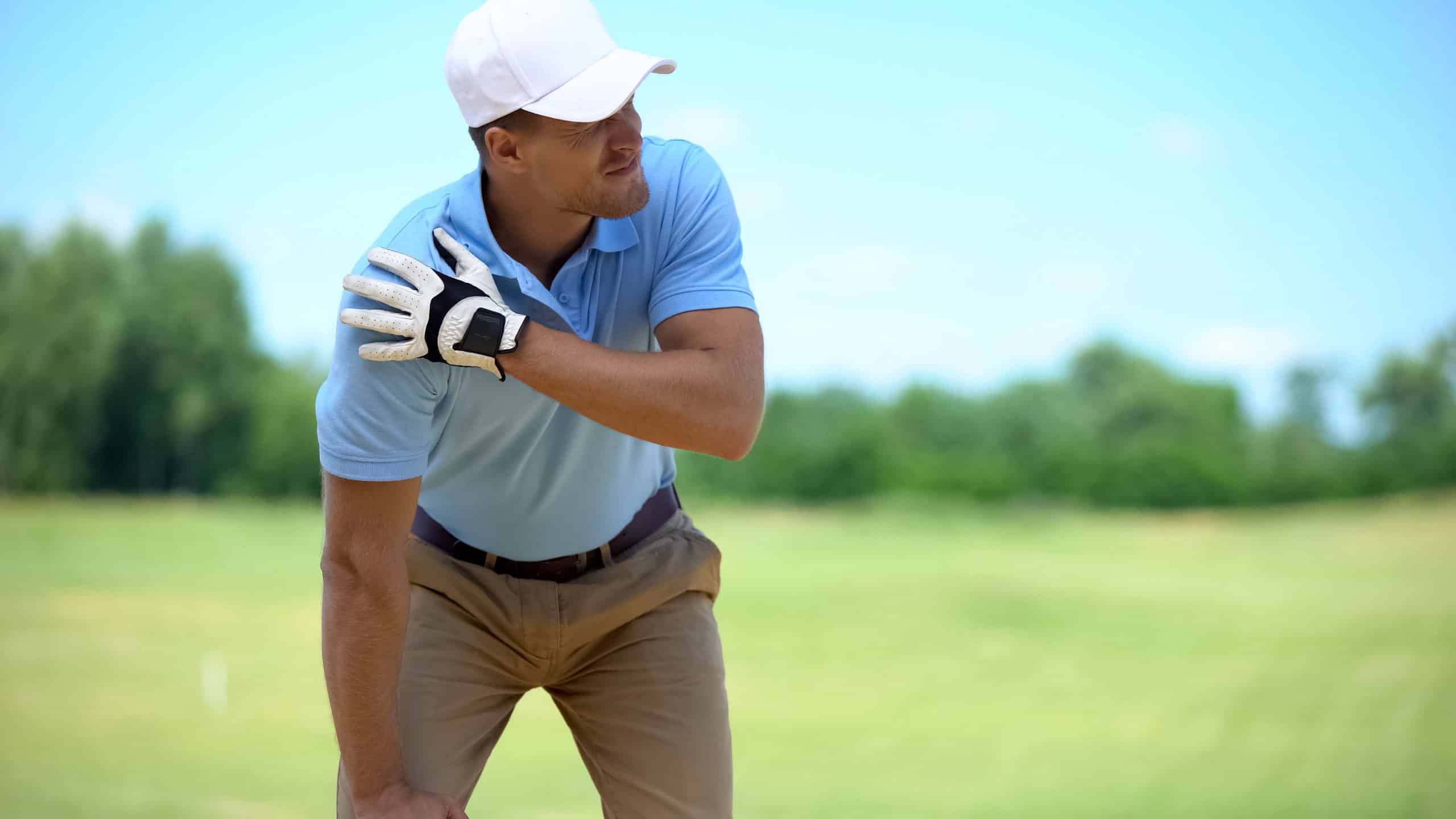 Golfer holding shoulder in pain
