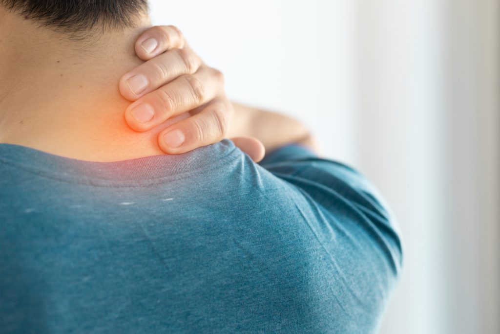 Patient indicates pain in neck by touching back of neck