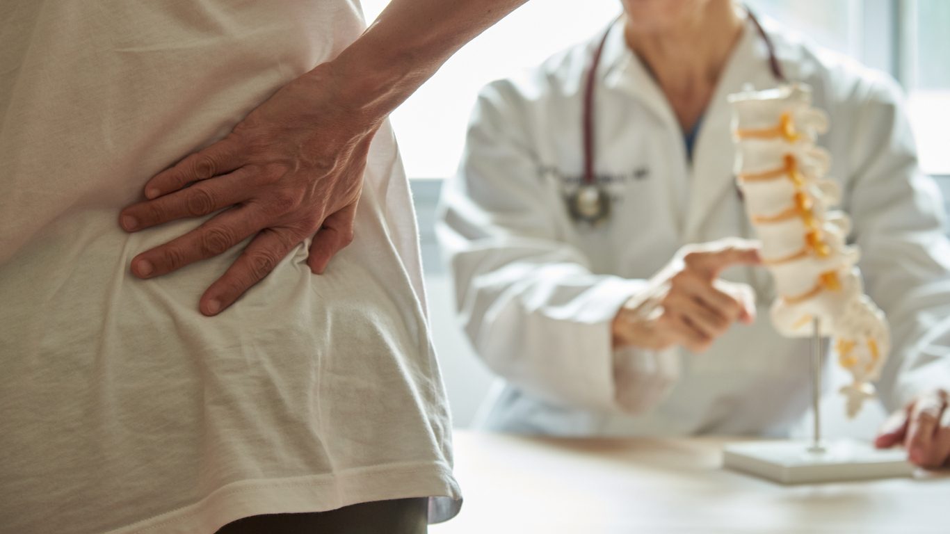 Doctor explaining lumbar anatomy to patient with back pain