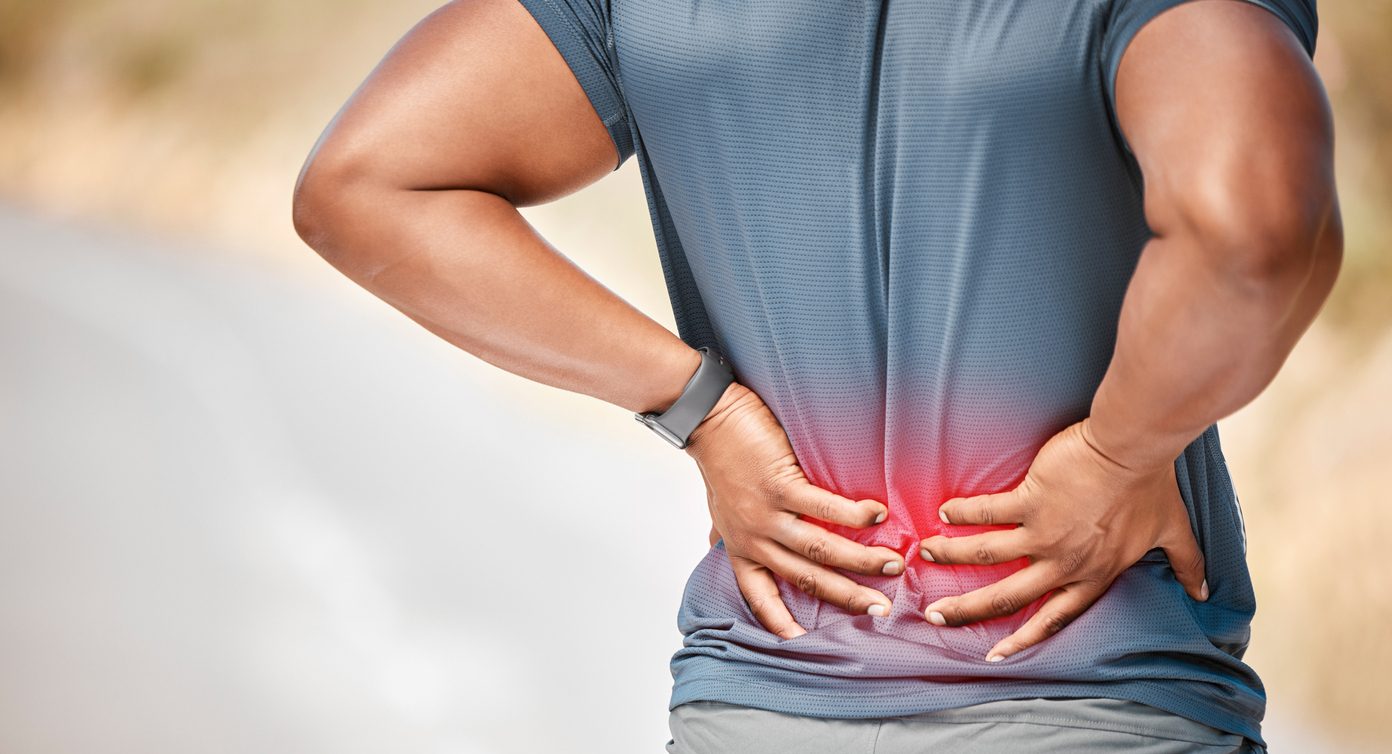 Rear view of a man holding his back in pain