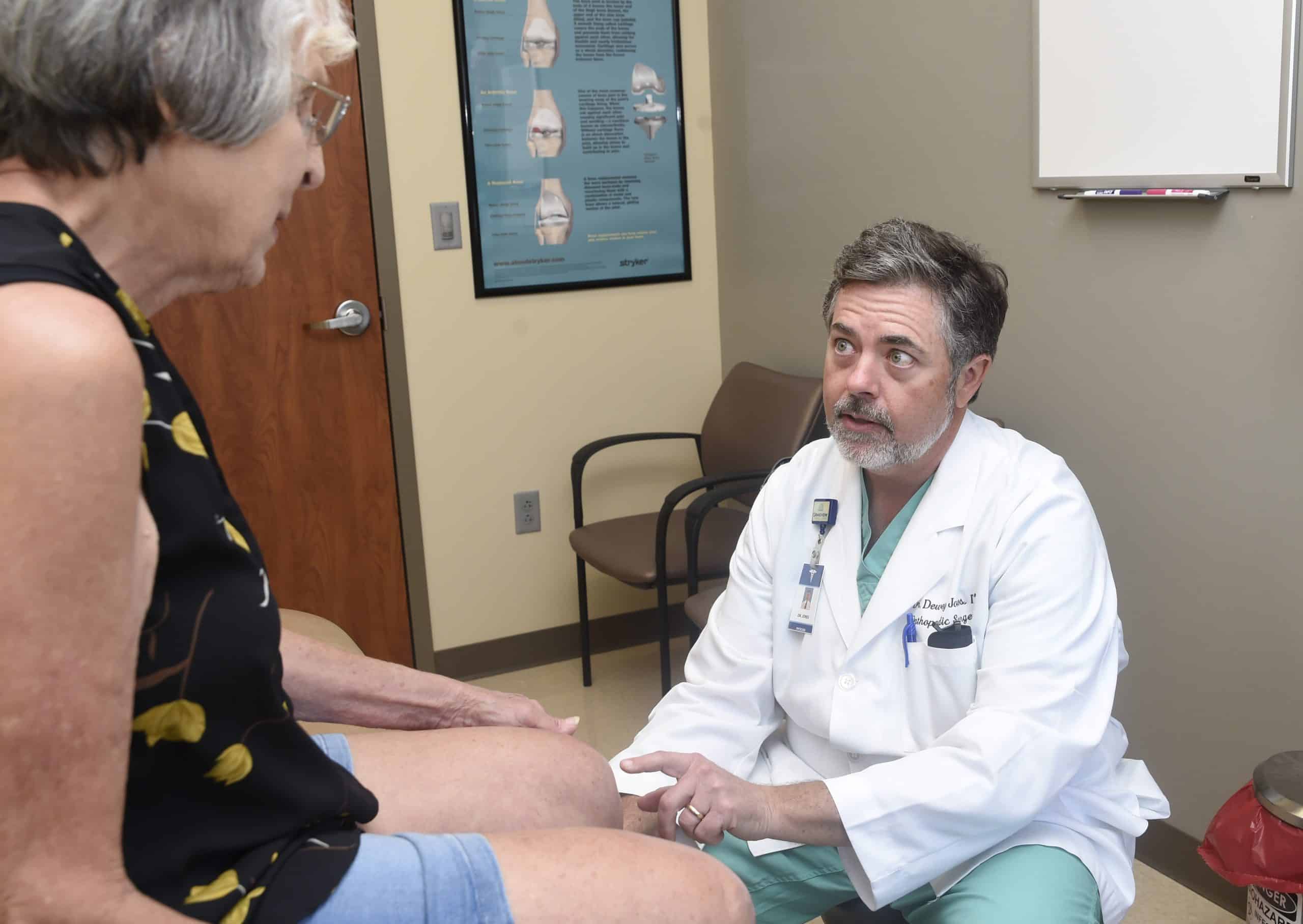 Southlake Orthopaedics’ Dr. Dewey H. Jones, MD providing arthritis care by examining a female patient’s knee for arthritis