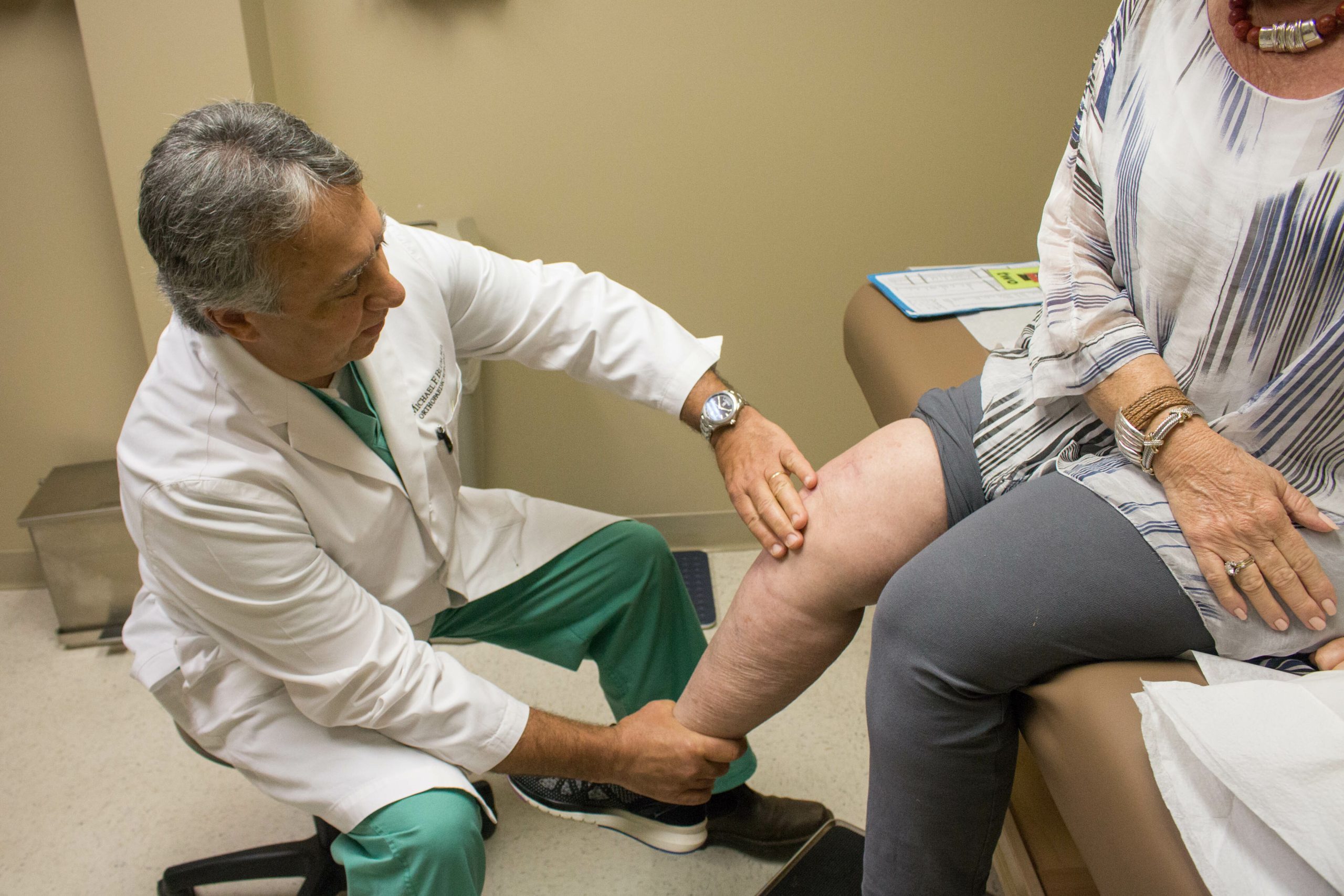 Southlake Orthopaedics’ Dr. Michael F. Blum, MD providing knee care by examining a female patient’s knee for arthritis