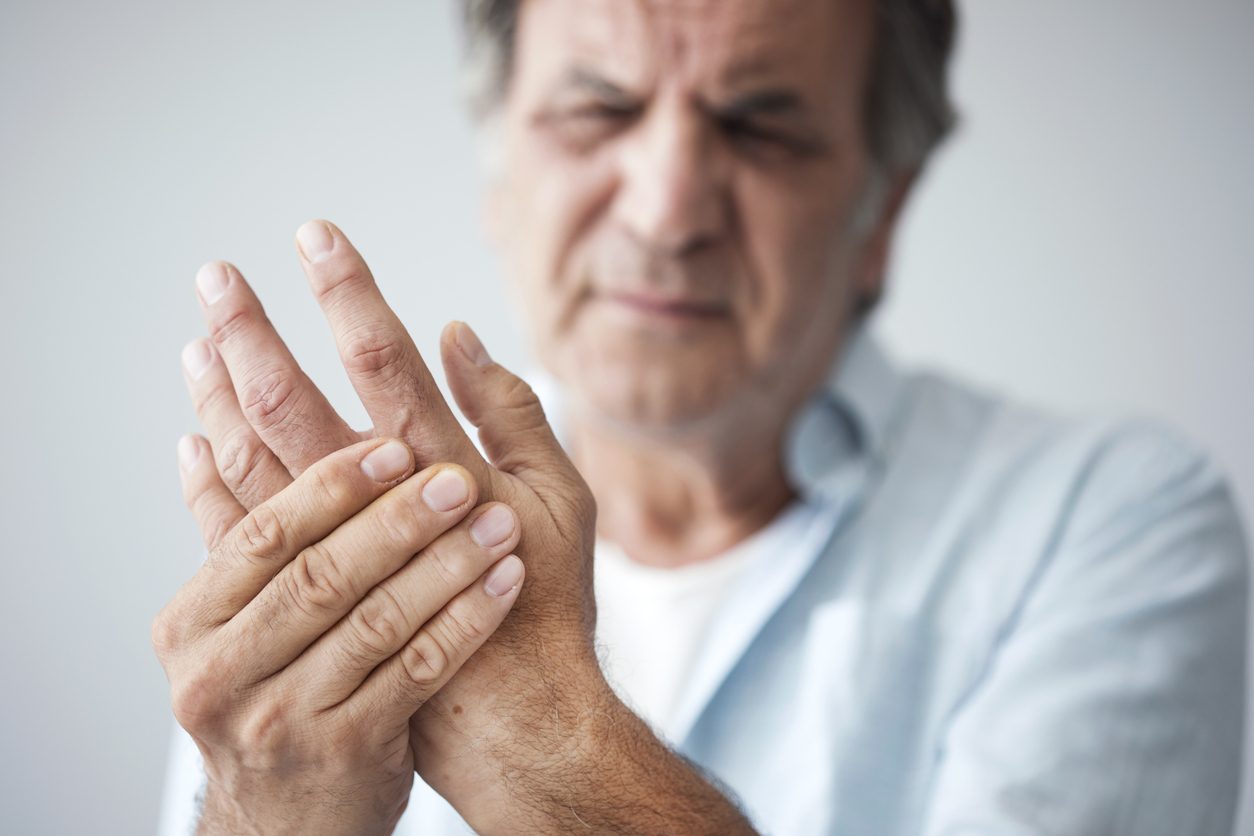 Older patient clutching hand in pain