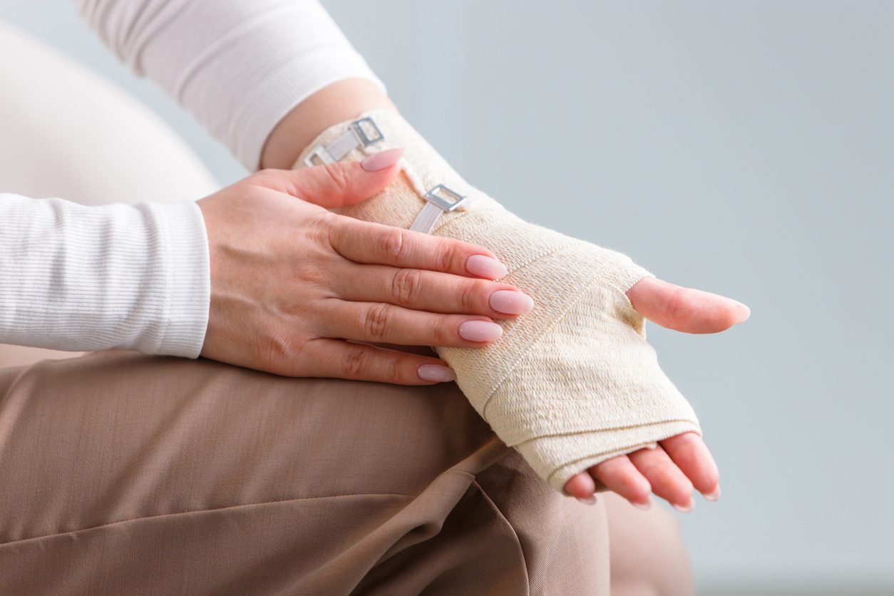 Patient holding sprained wrist in bandage wrap