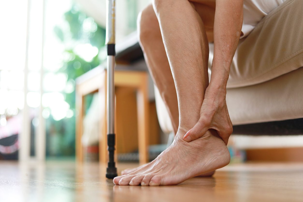 Patient clutching heel because of arthritis pain