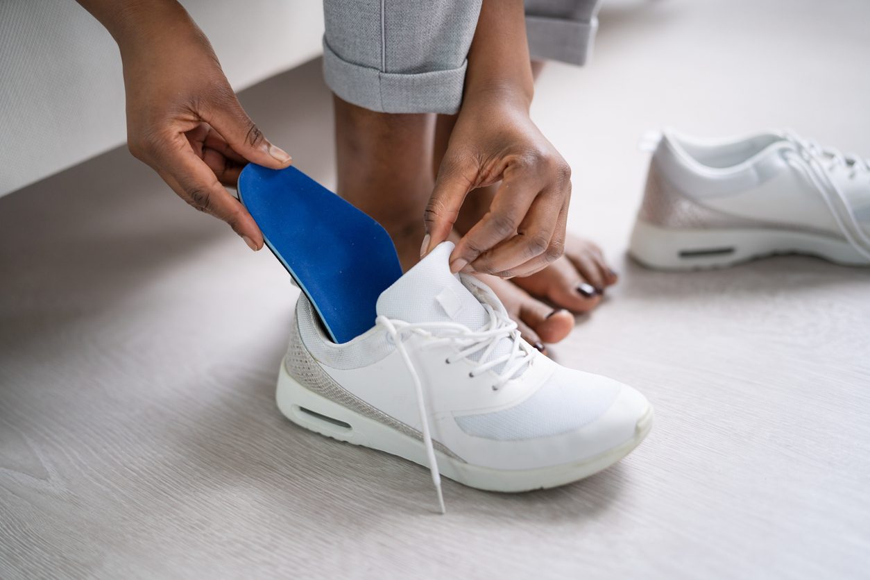 Patient inserting custom heel insert into shoe