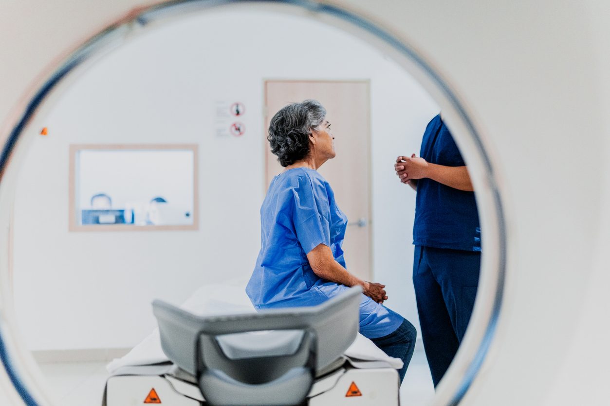 Patient on MRI scan bed talking to nurse