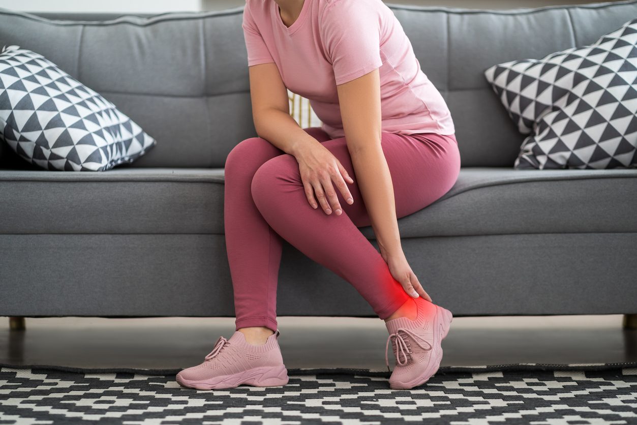 Patient reaching for foot because of pain and inflammation from heel spurs