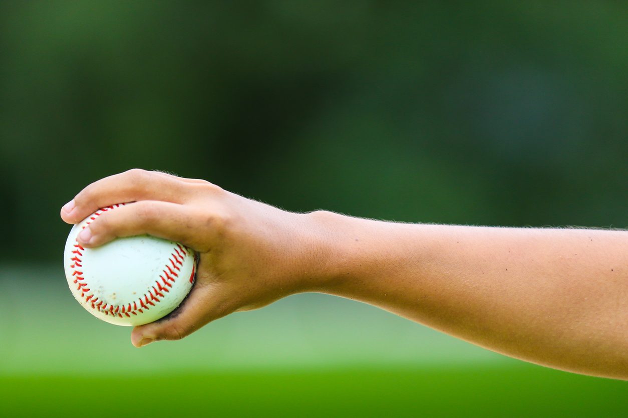 Close-up of baseball in athlete’s hand performing OT from a sports injury