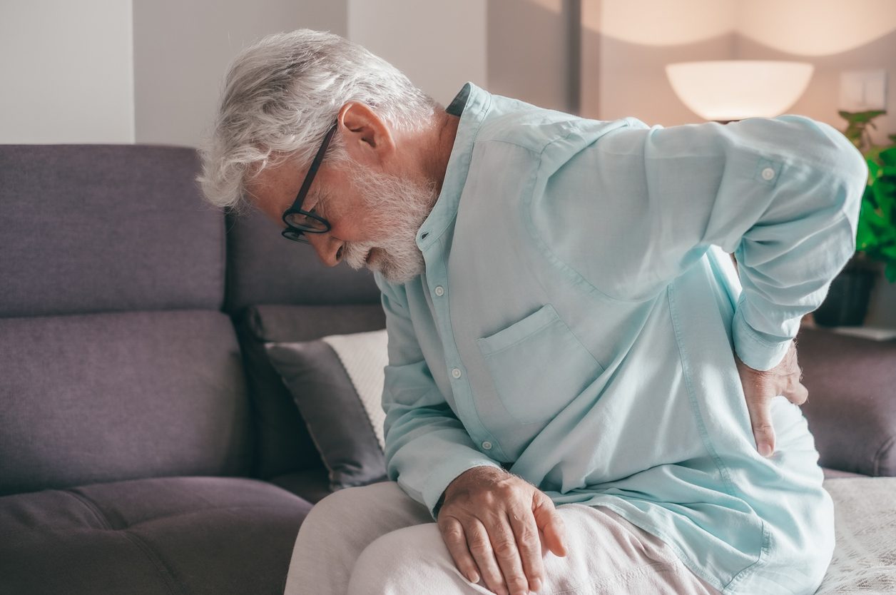 Senior patient holding back in pain