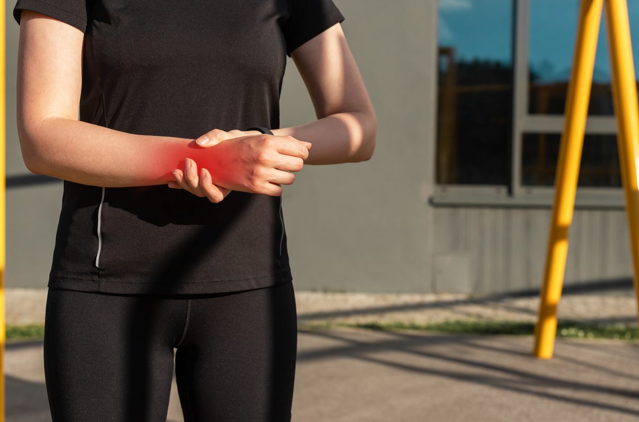 Athletic person clutching wrist in pain due to overuse