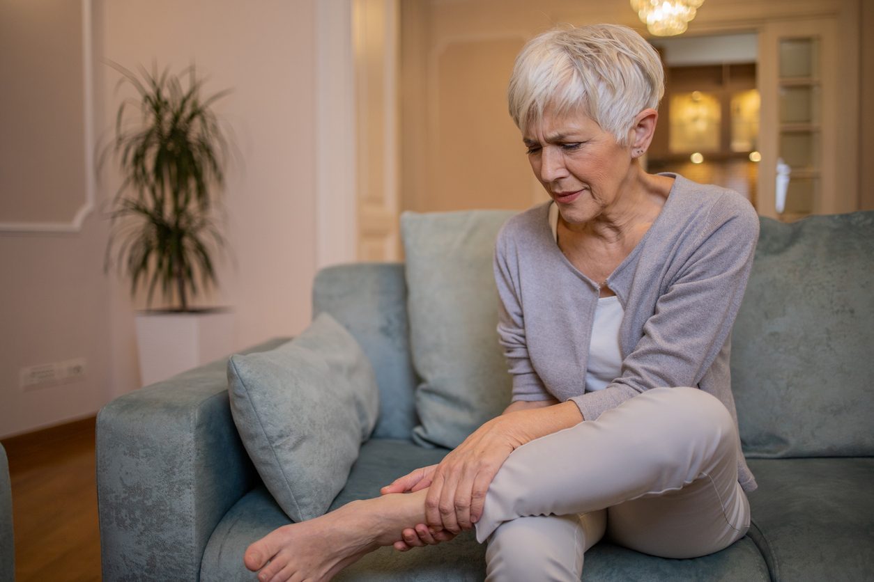 Patient grips ankle due to arthritis pain