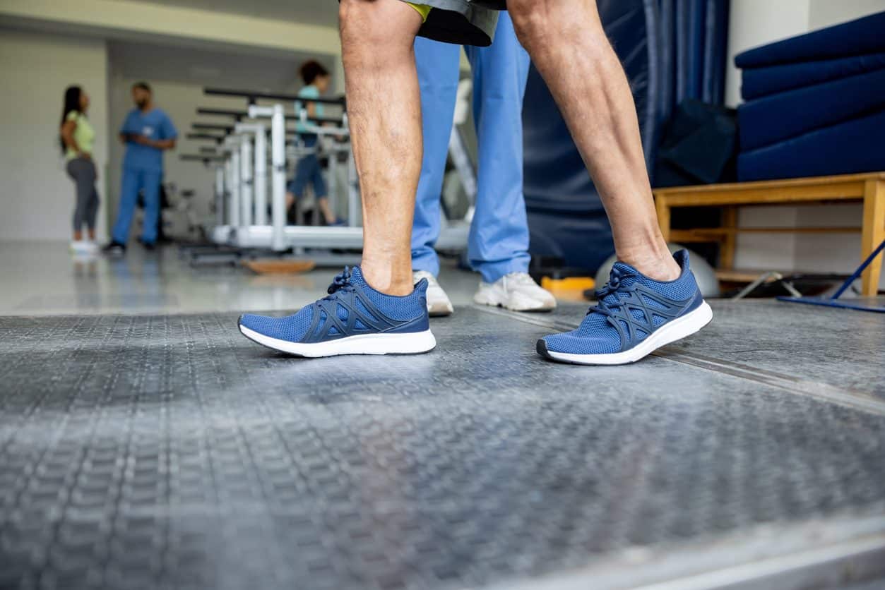Physical therapist helping patient with gait problems regain balance
