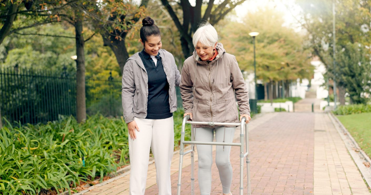 Senior woman walking in park post knee replacement