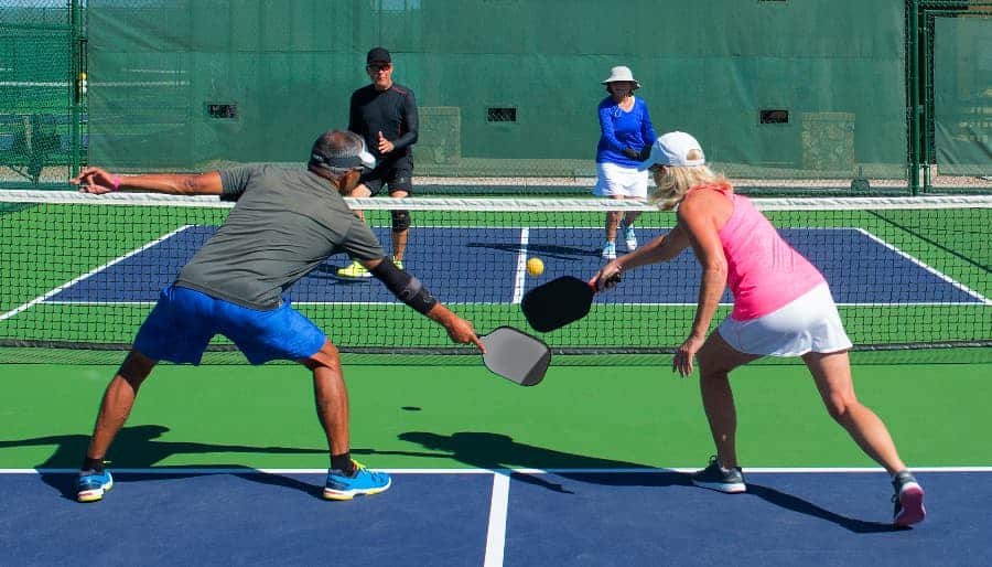 Two couples compete against each other on pickleball court